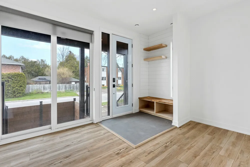 Before: an empty entryway with glass doors, a small bench and wall shelves