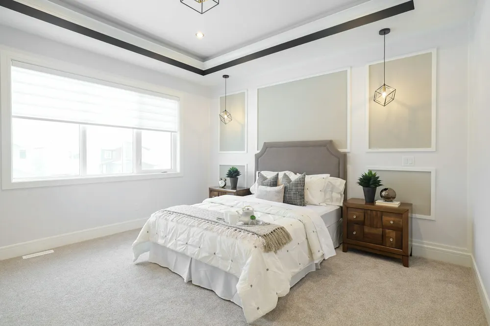 Before: a new-build bedroom with a tray ceiling and an upholstered bed