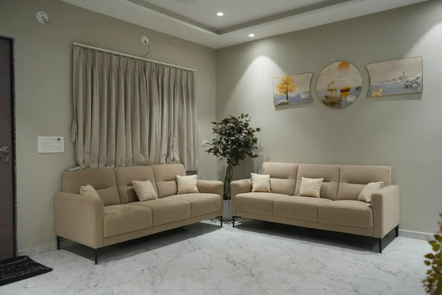 Before: plain living room with two beige sofas and a marble floor