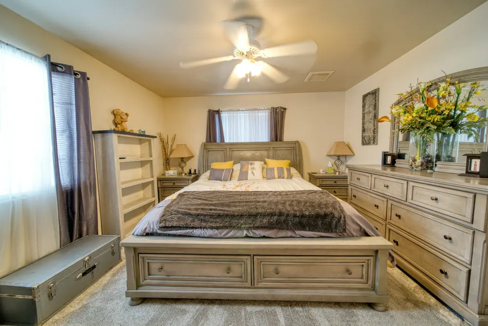 Before: a cottage-style bedroom with a grey-washed bed and long dresser
