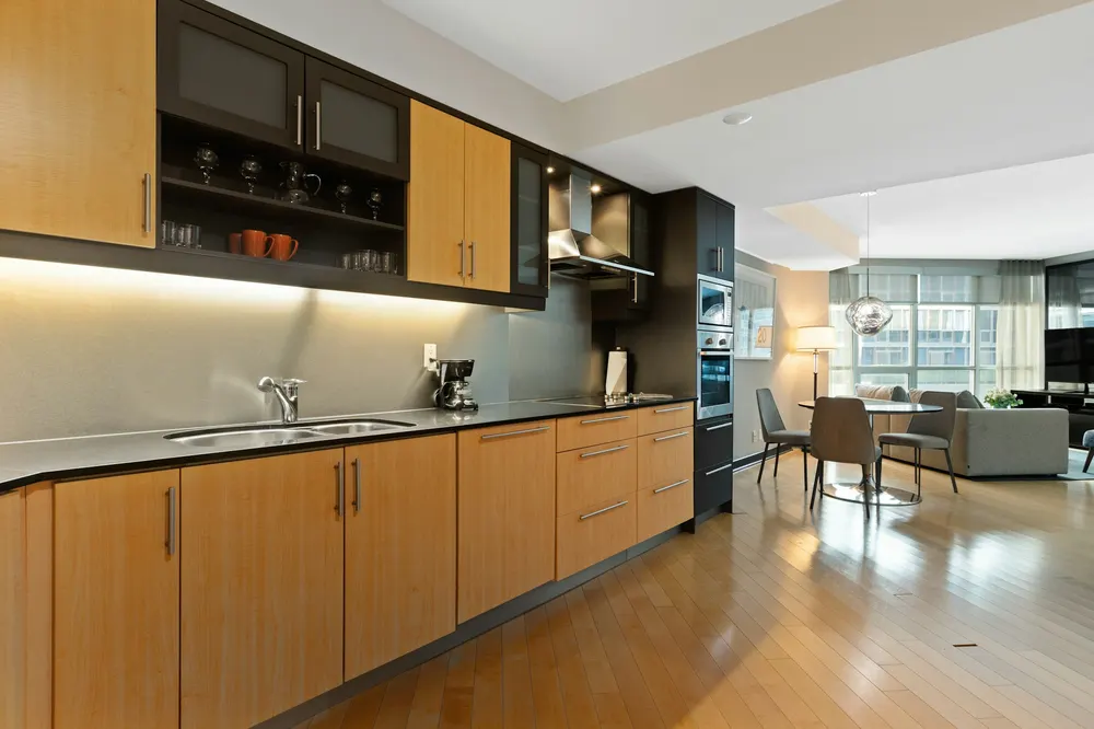 Before: a long kitchen with maple cabinets and a dark upper unit